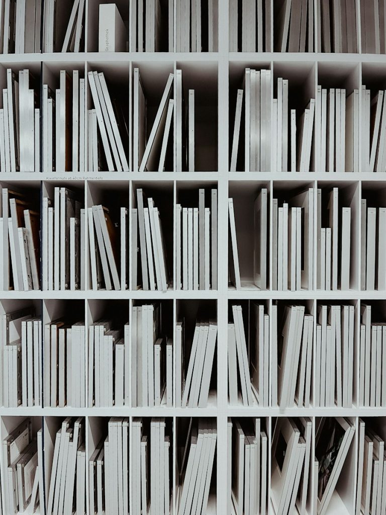a book shelf filled with lots of white books